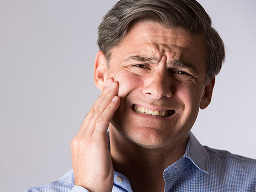 Man-with-Mouth-Pain | Smiles Unlimited family smiling together