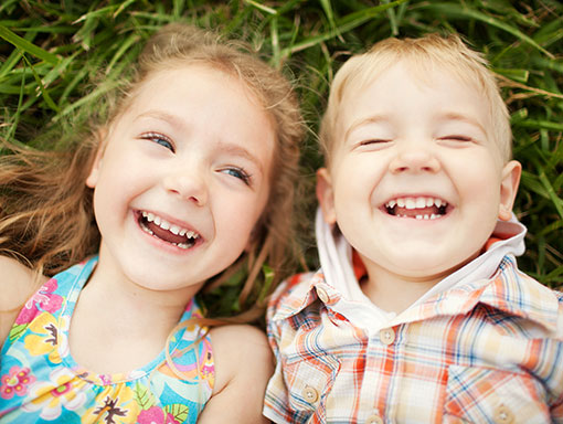 family on couch showing teeth smiling