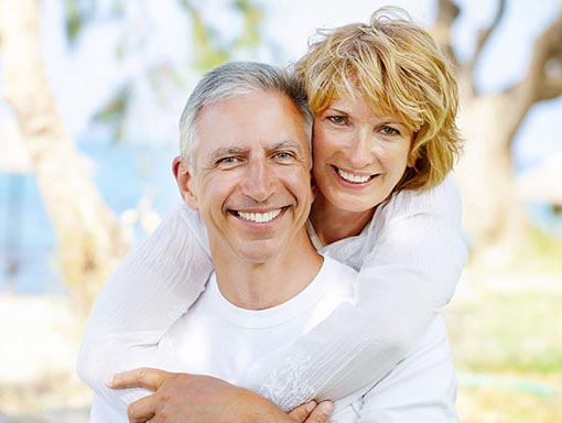 elderly couple hugging and smiling