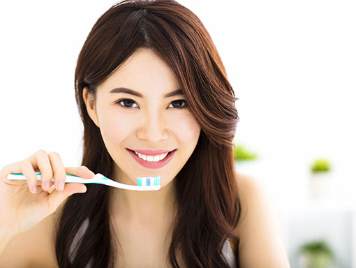 girl smiling with toothbrush | Smiles Unlimited